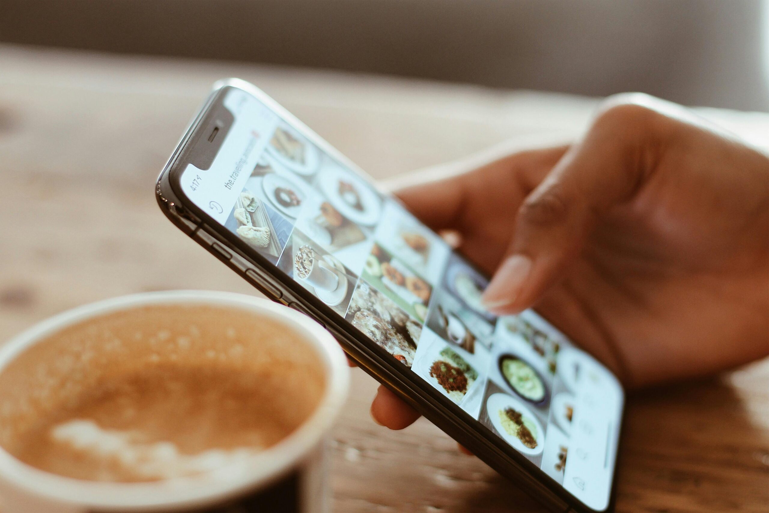 Main tenant un smartphone et scrollant sur son Feed Instagram