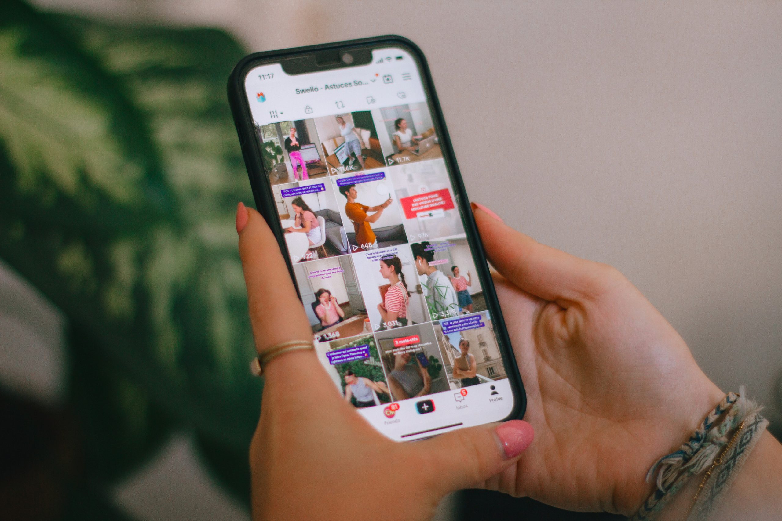 Deux mains tenant un smartphone sur un profil TikTok